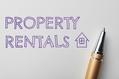 Image of Text Property Rentals and pen on white paper, top view