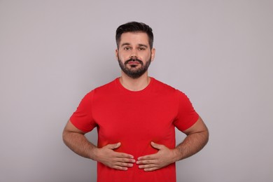 Photo of Man suffering from stomach pain on grey background