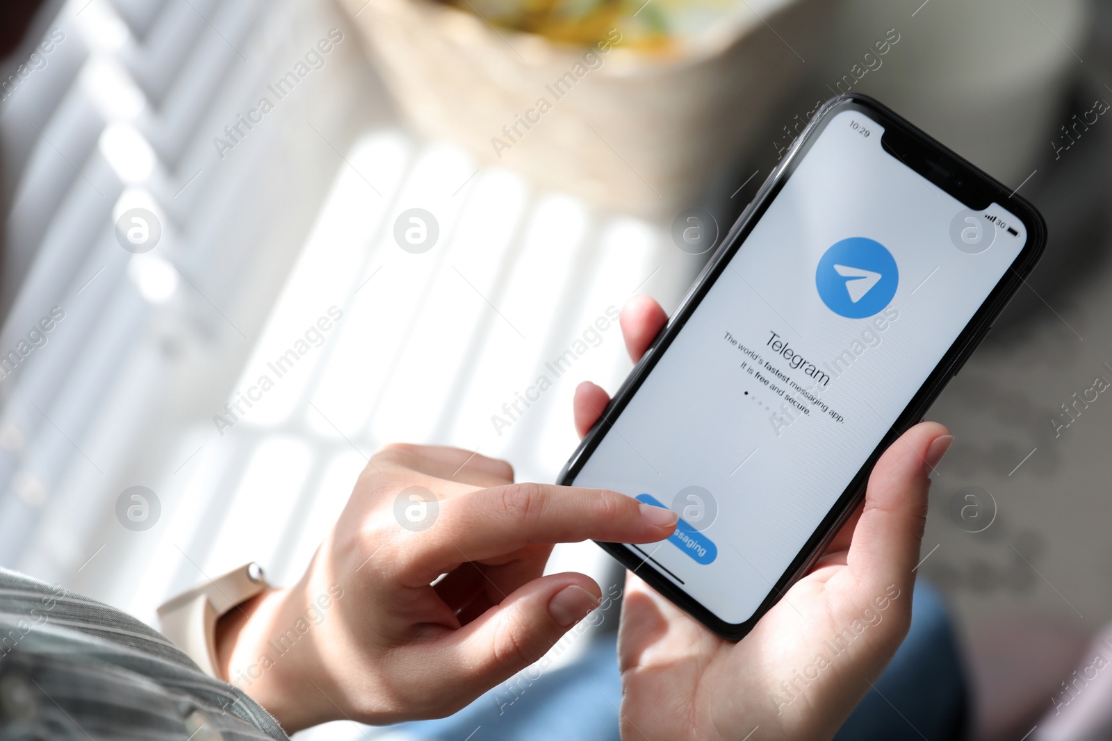 Photo of MYKOLAIV, UKRAINE - MARCH 16, 2020: Woman holding iPhone 11 with Telegram app on screen indoors, closeup