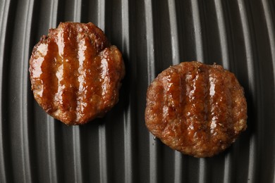 Photo of Delicious hamburger patties on electric grill, top view