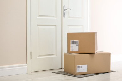 Photo of Parcels on rug near door. Delivery service