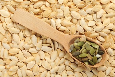 Wooden spoon on pumpkin seeds, top view