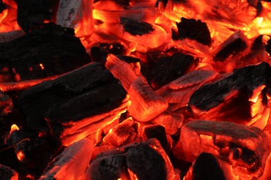 Photo of Pieces of hot smoldering coal as background, closeup