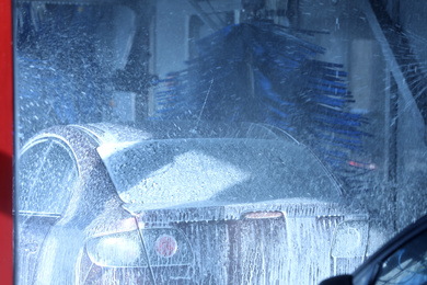 Modern auto undergoing cleaning at car wash