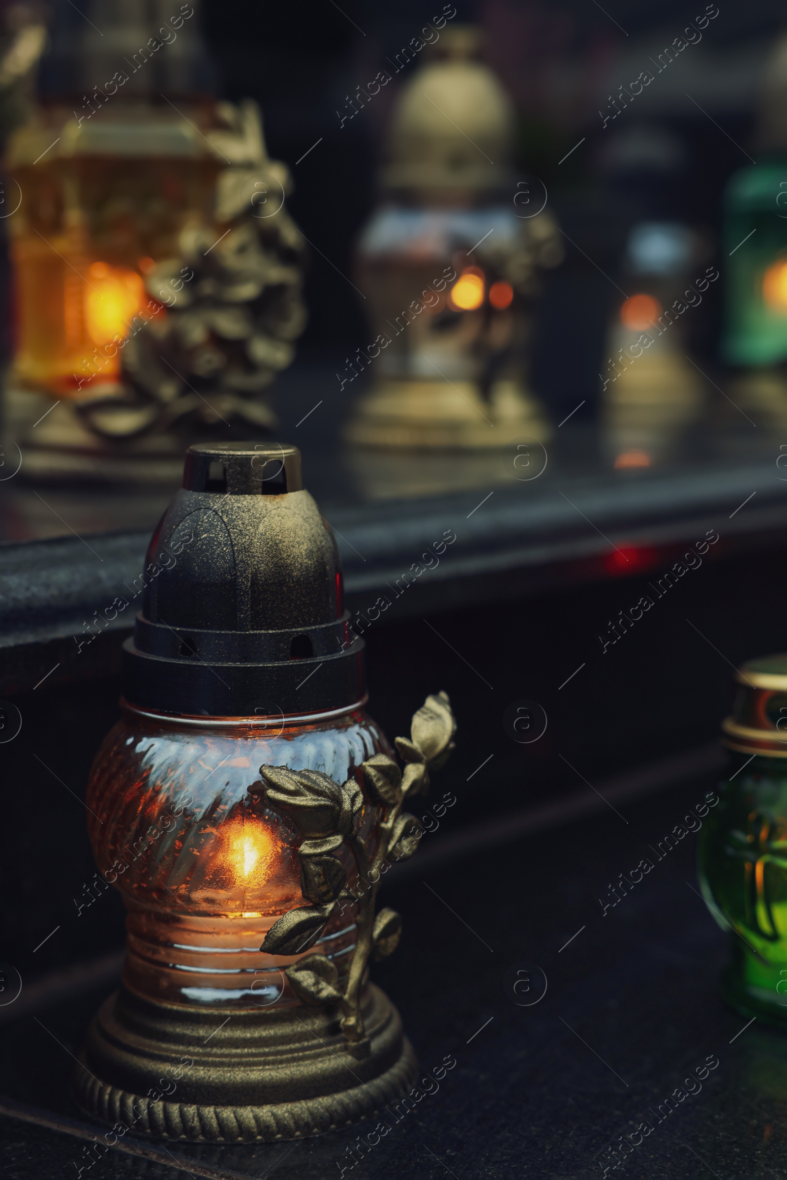 Photo of Grave lights on granite surface at cemetery