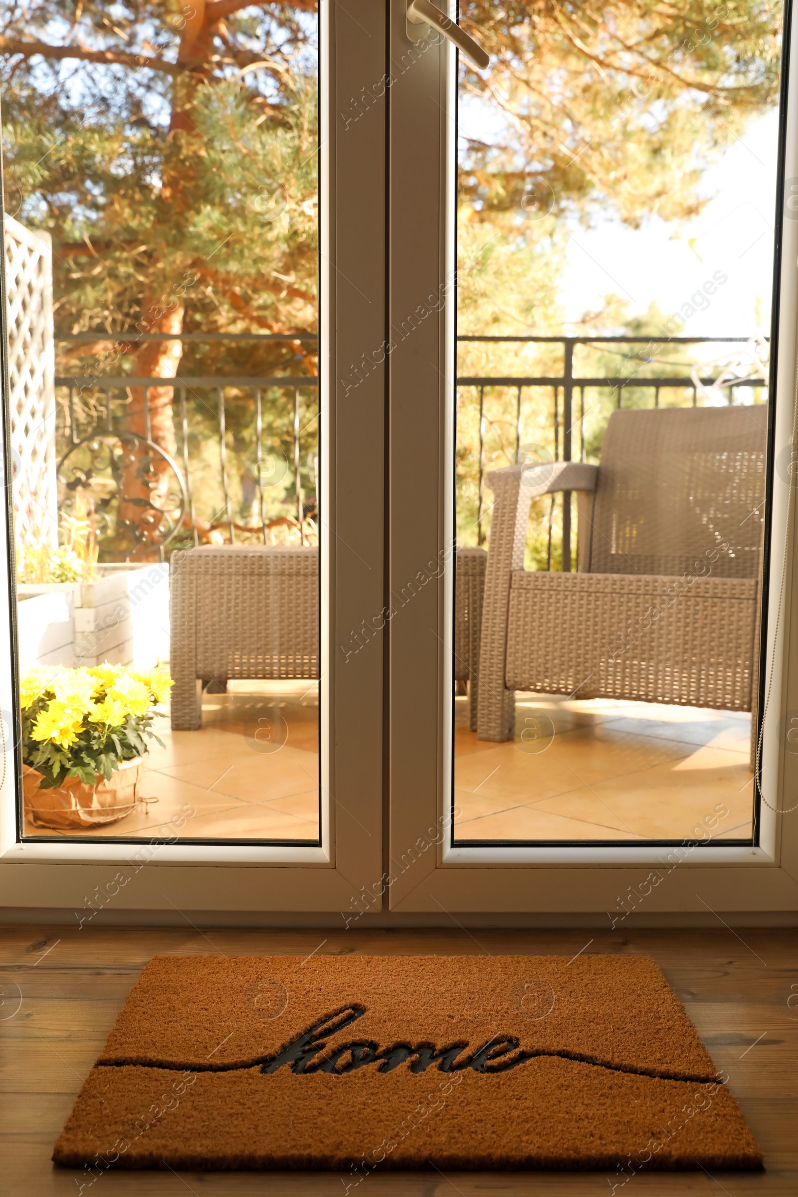 Photo of Doormat with word Home on parquet floor indoors