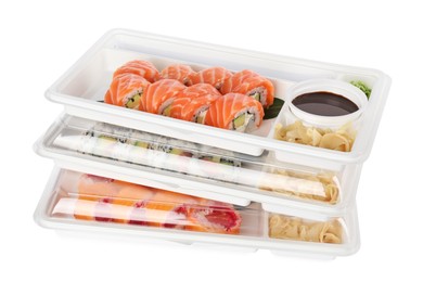 Photo of Food delivery. Containers with different delicious sushi rolls on white background
