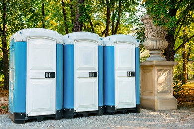 Photo of Public toilet cabins on street near trees