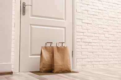 Paper bags on door mat near entrance indoors