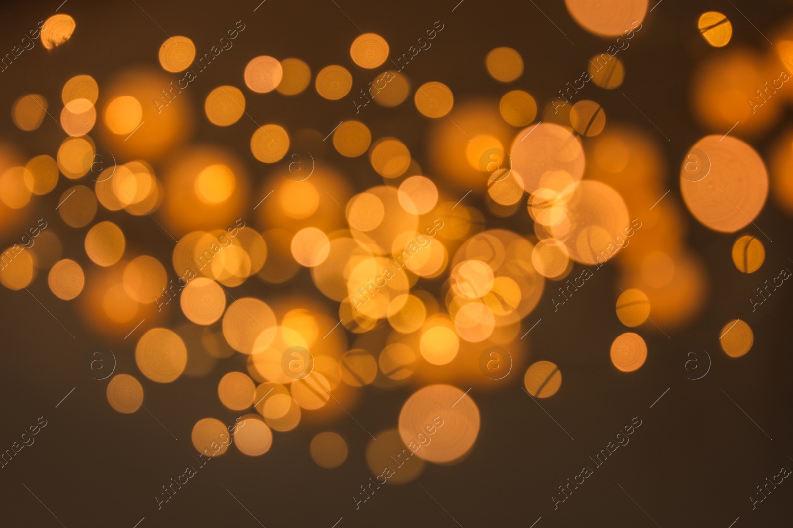 Photo of Blurred view of gold lights on dark background. Bokeh effect