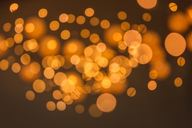 Blurred view of gold lights on dark background. Bokeh effect