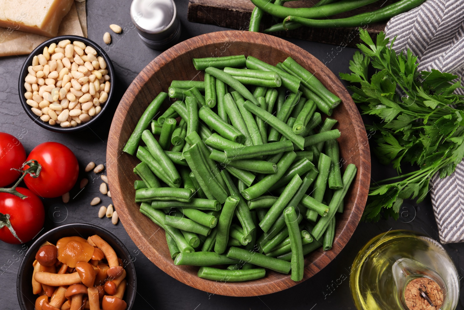 Photo of Fresh green beans and other ingredients for salad on black table, flat lay
