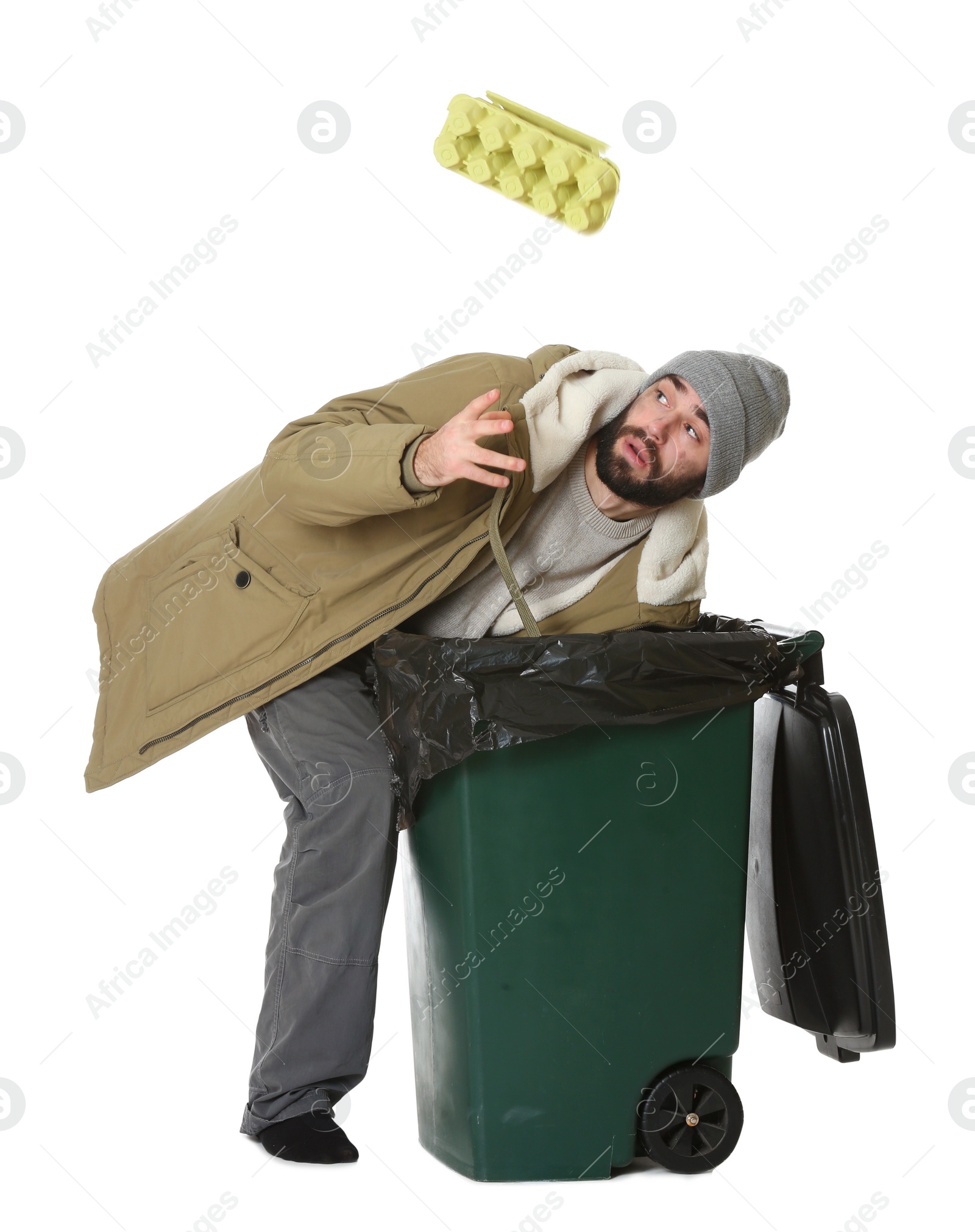 Photo of Poor homeless man digging in trash bin isolated on white