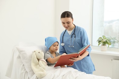 Childhood cancer. Doctor and patient reading book in hospital