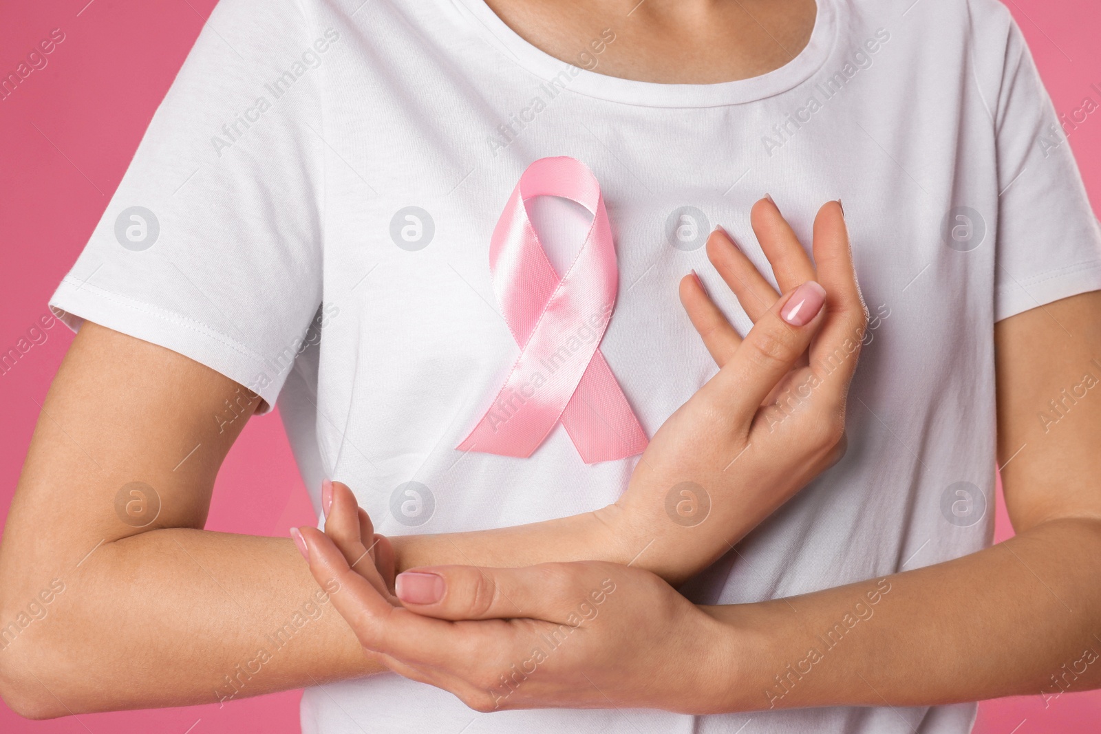 Photo of Woman with pink ribbon on color background, closeup. Breast cancer awareness