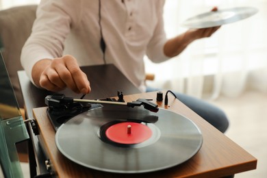 Man using turntable at home, closeup view