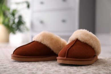 Photo of Brown warm slippers on floor in room