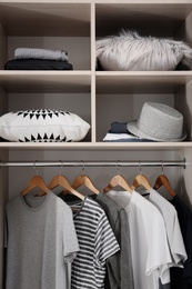 Photo of Stylish clothes and home stuff in large wardrobe closet