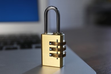 Photo of Cyber security. Laptop with padlock on table, closeup