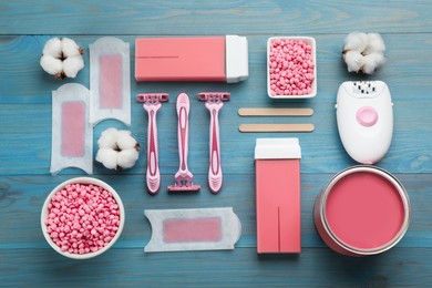 Photo of Set of epilation products on light blue wooden table, flat lay