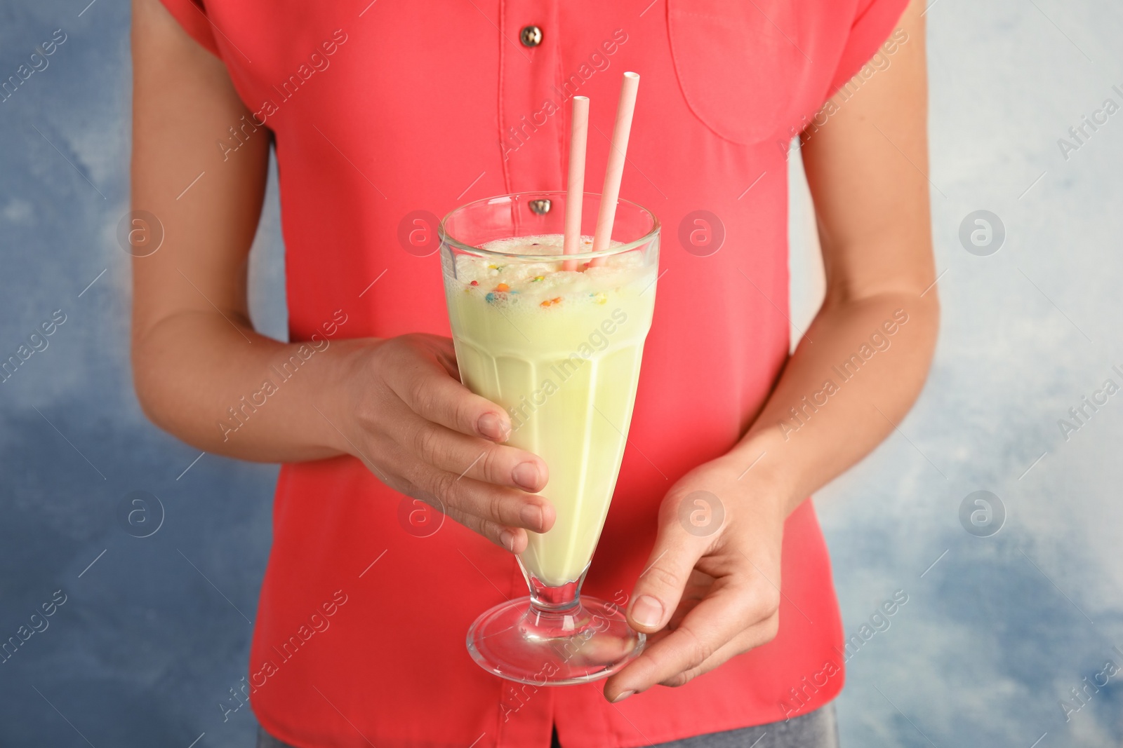 Photo of Woman with glass of delicious milk shake on color background, closeup