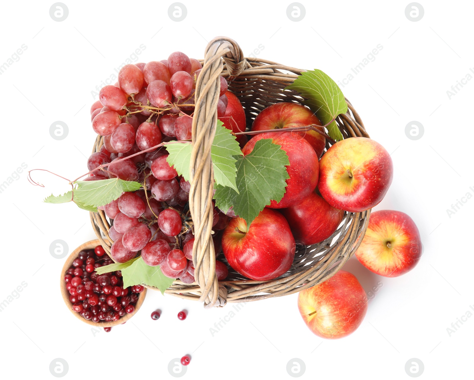 Photo of Wicker basket with fresh fruits and berries on white background, above view