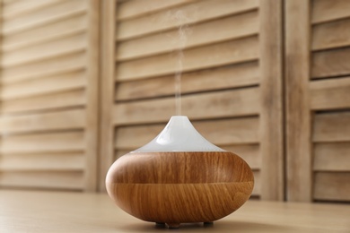 Photo of Modern aroma lamp on wooden table