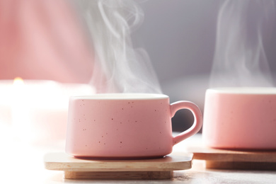 Photo of Cup of hot drink on white table against blurred background