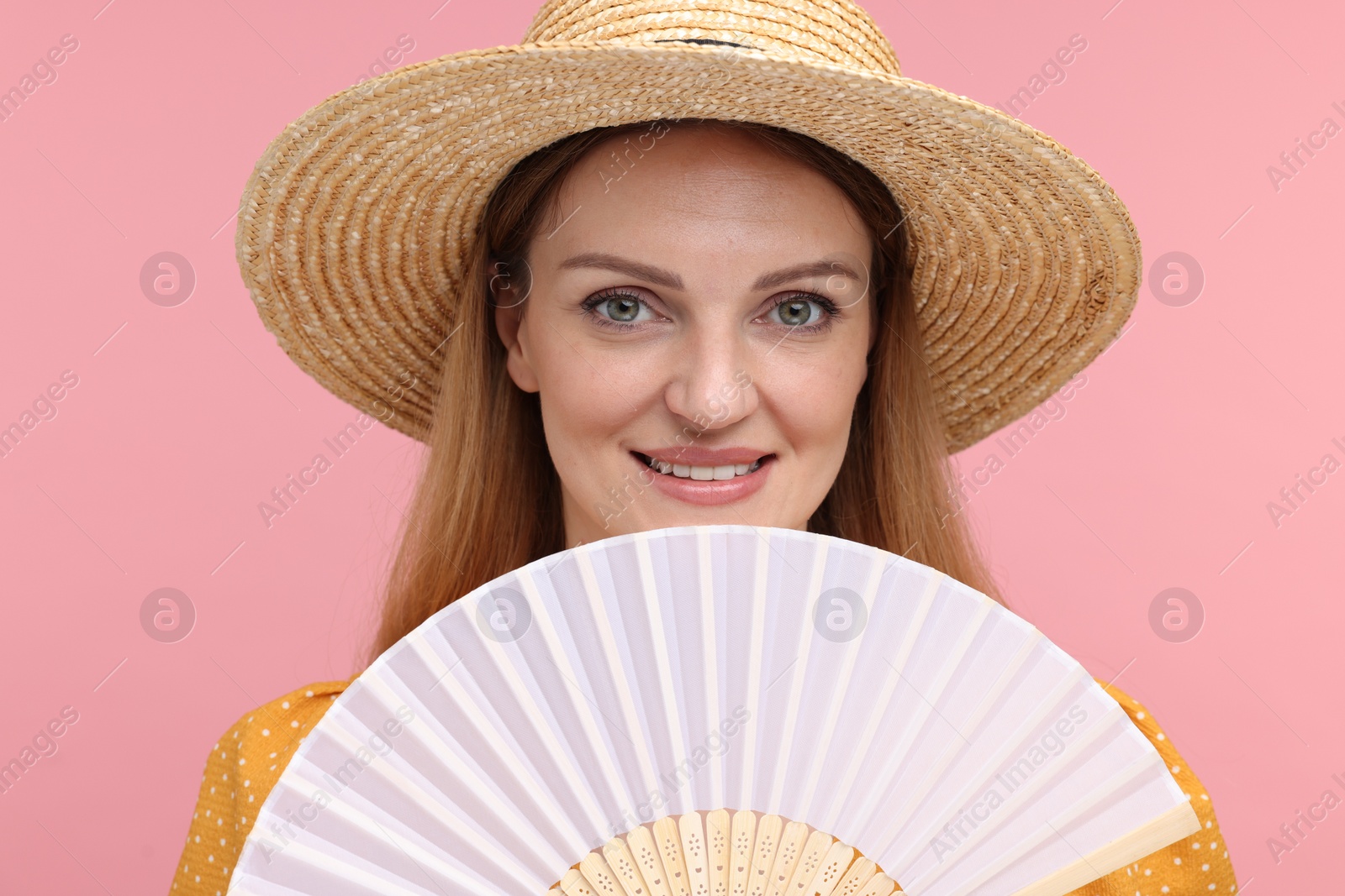 Photo of Happy woman with hand fan on pink background