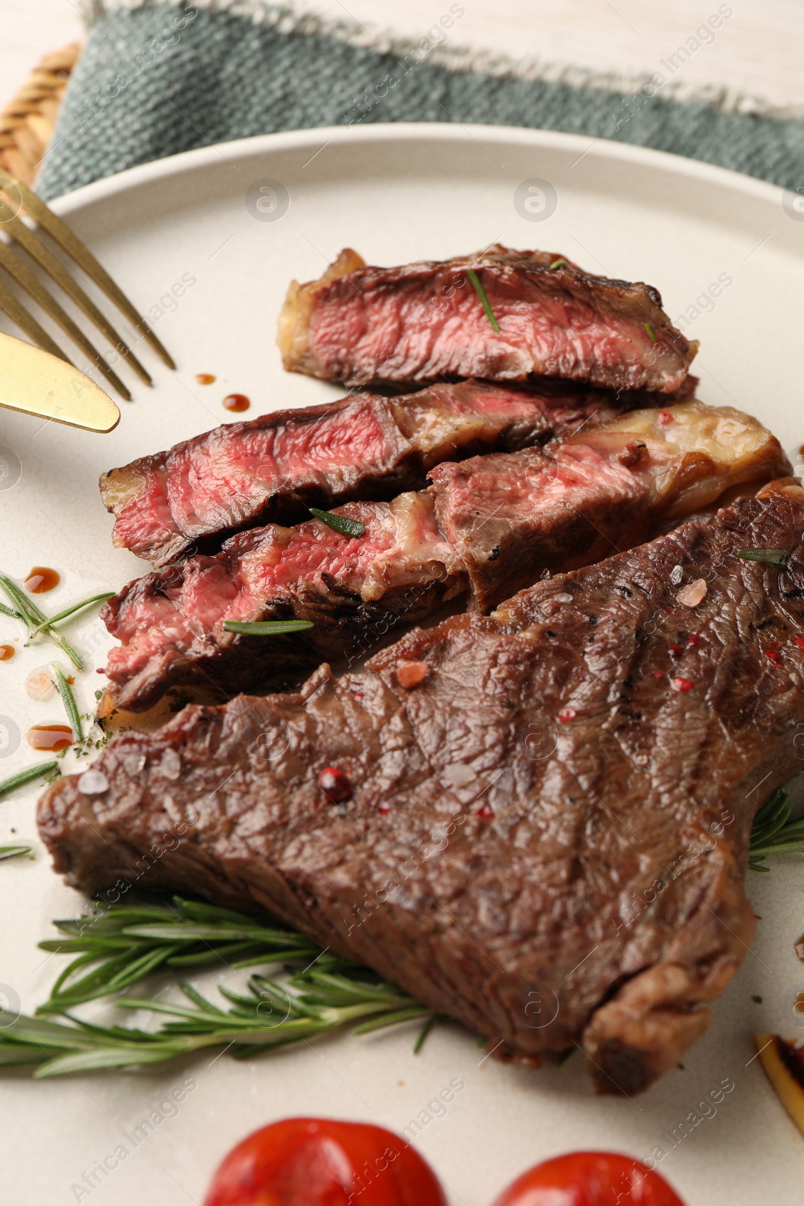 Photo of Delicious grilled beef steak and rosemary on plate, closeup