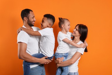 Photo of Happy international family with children on orange background
