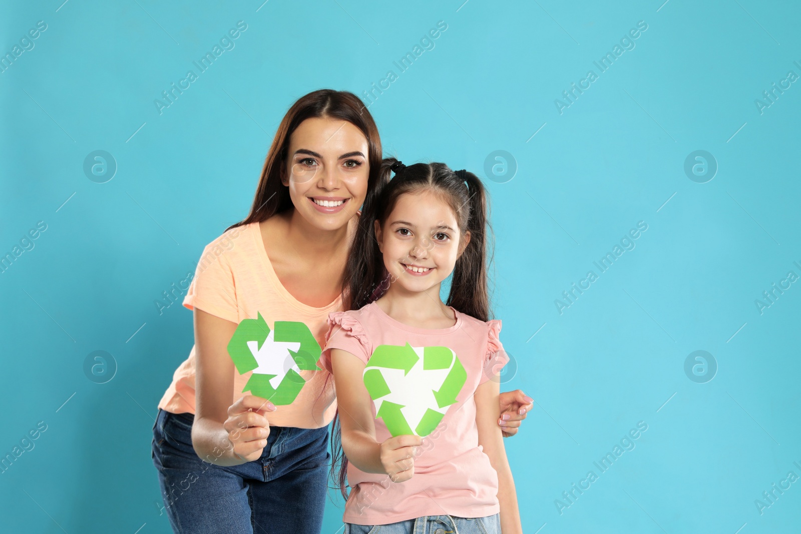 Photo of Mother and daughter with recycling symbols on blue background