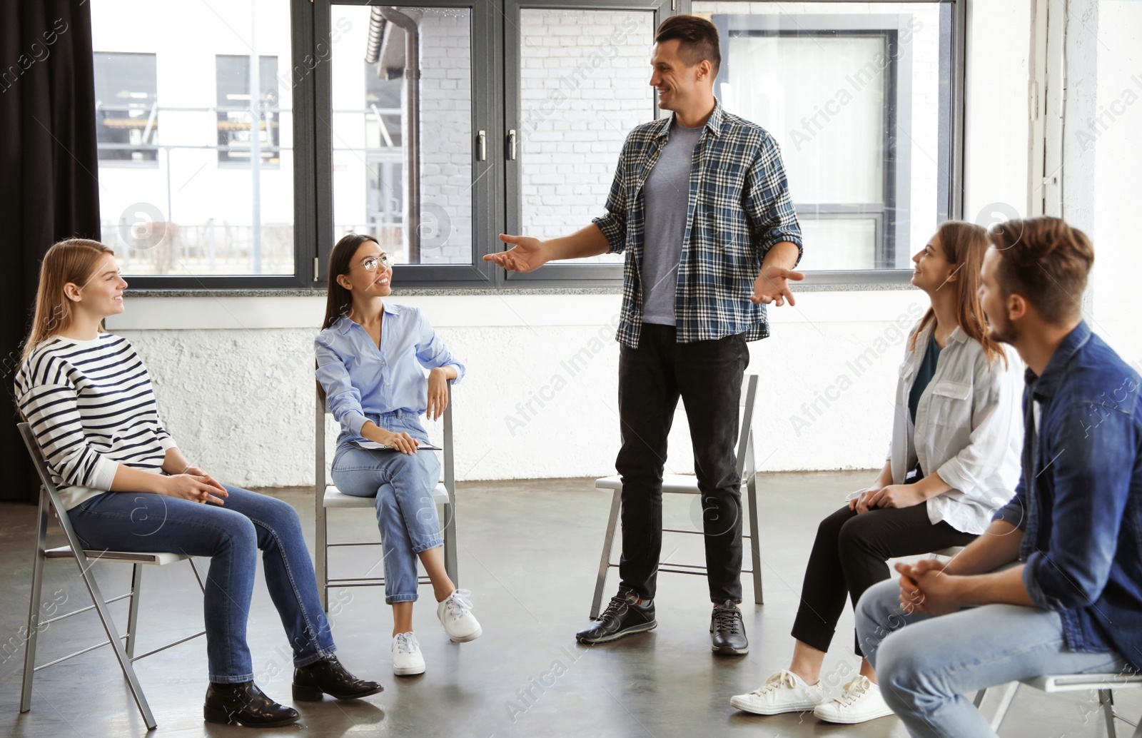 Photo of Psychotherapist working with patients in group therapy session indoors