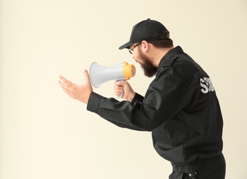 Security guard shouting into megaphone indoors