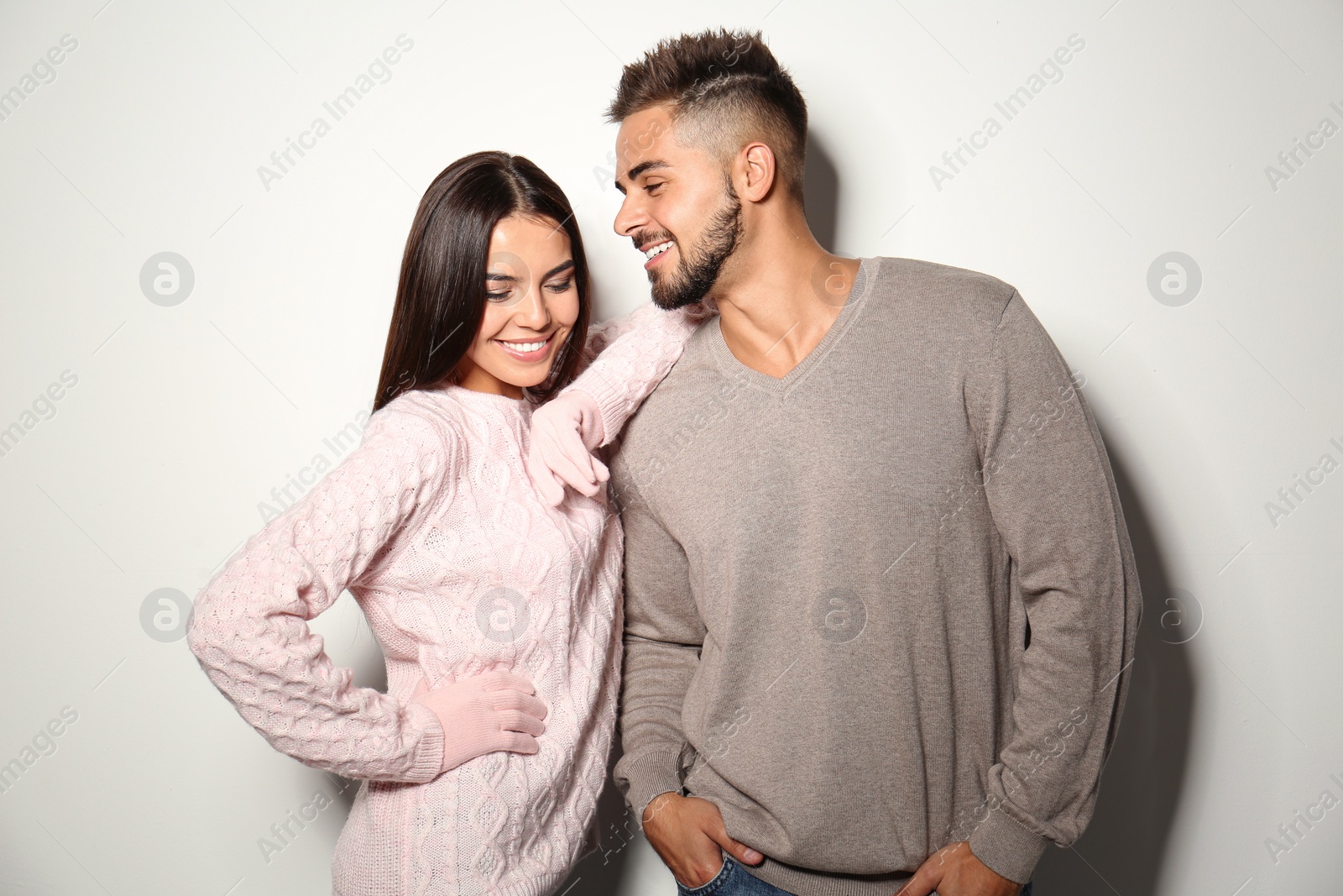 Image of Lovely couple in warm sweaters on light background 