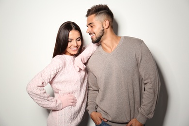 Lovely couple in warm sweaters on light background 