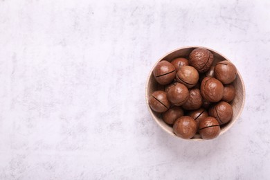 Delicious organic Macadamia nuts on light gray table, top view. Space for text