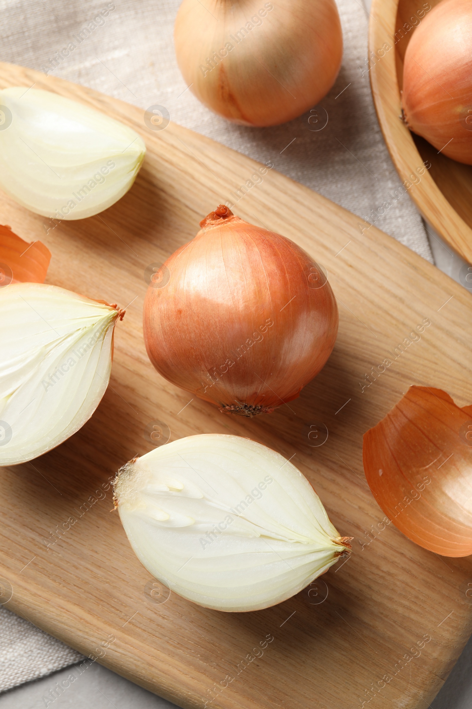 Photo of Whole and cut onions on table, flat lay