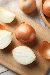 Whole and cut onions on table, flat lay