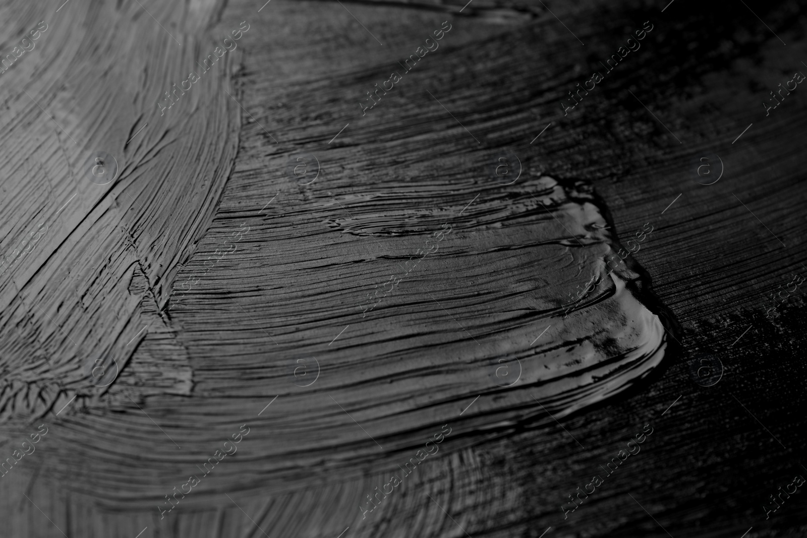 Photo of Beautiful strokes of black paint as background, closeup