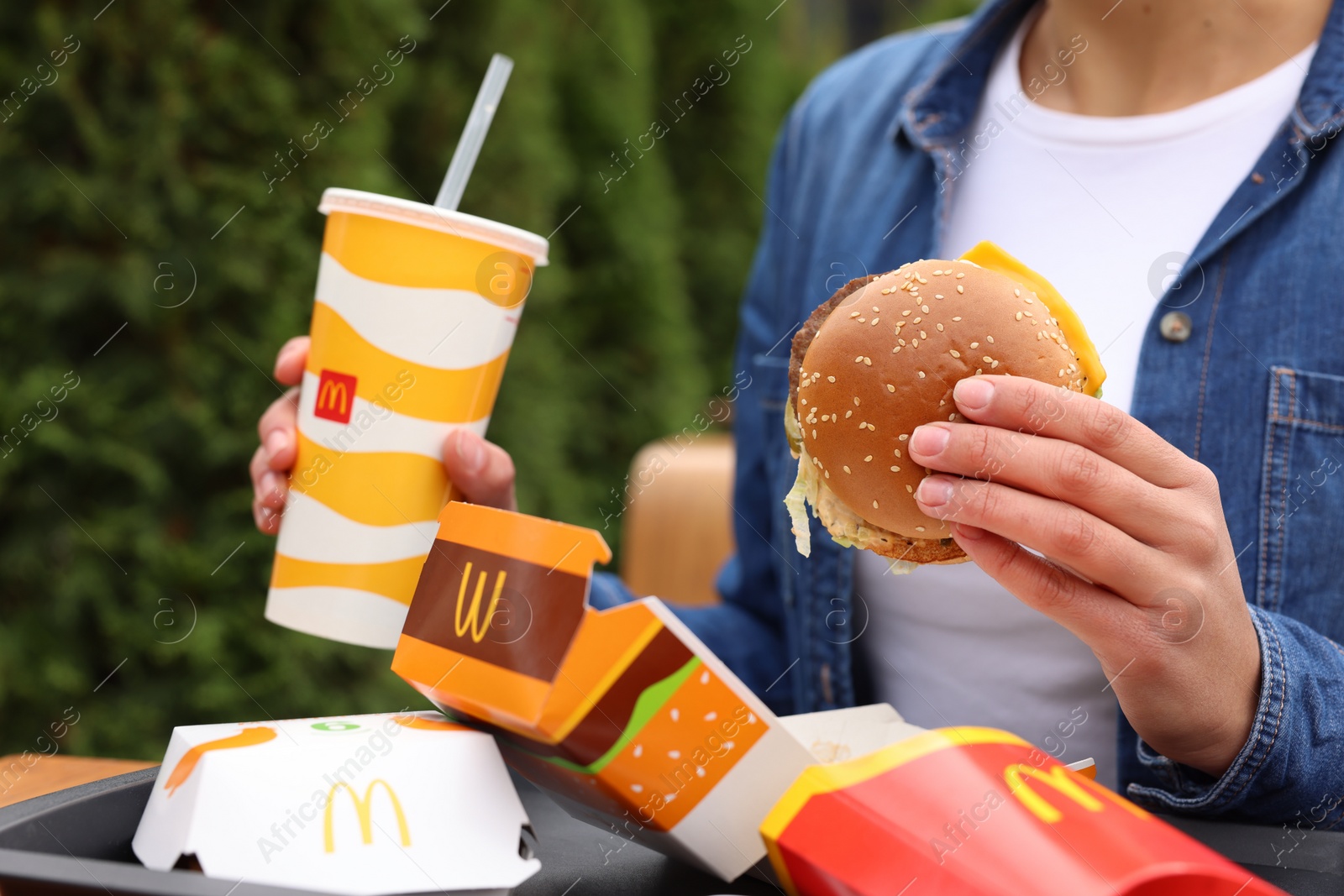 Photo of Lviv, Ukraine - October 9, 2023: Woman with McDonald's menu at table outdoors, closeup