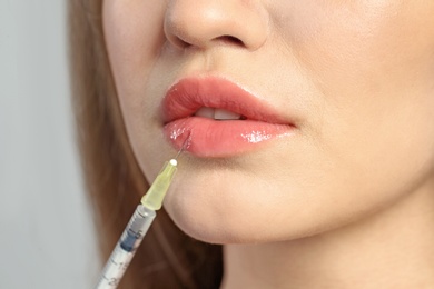 Photo of Young woman getting lips injection, closeup. Cosmetic surgery