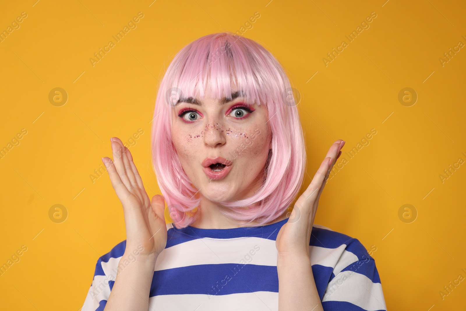 Photo of Surprised woman with bright makeup and glitter freckles on yellow background