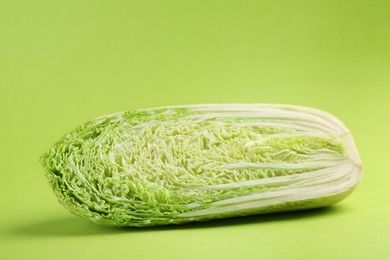 Photo of Half of fresh Chinese cabbage on light green background