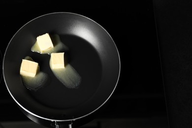 Photo of Melting butter in frying pan on cooktop, top view