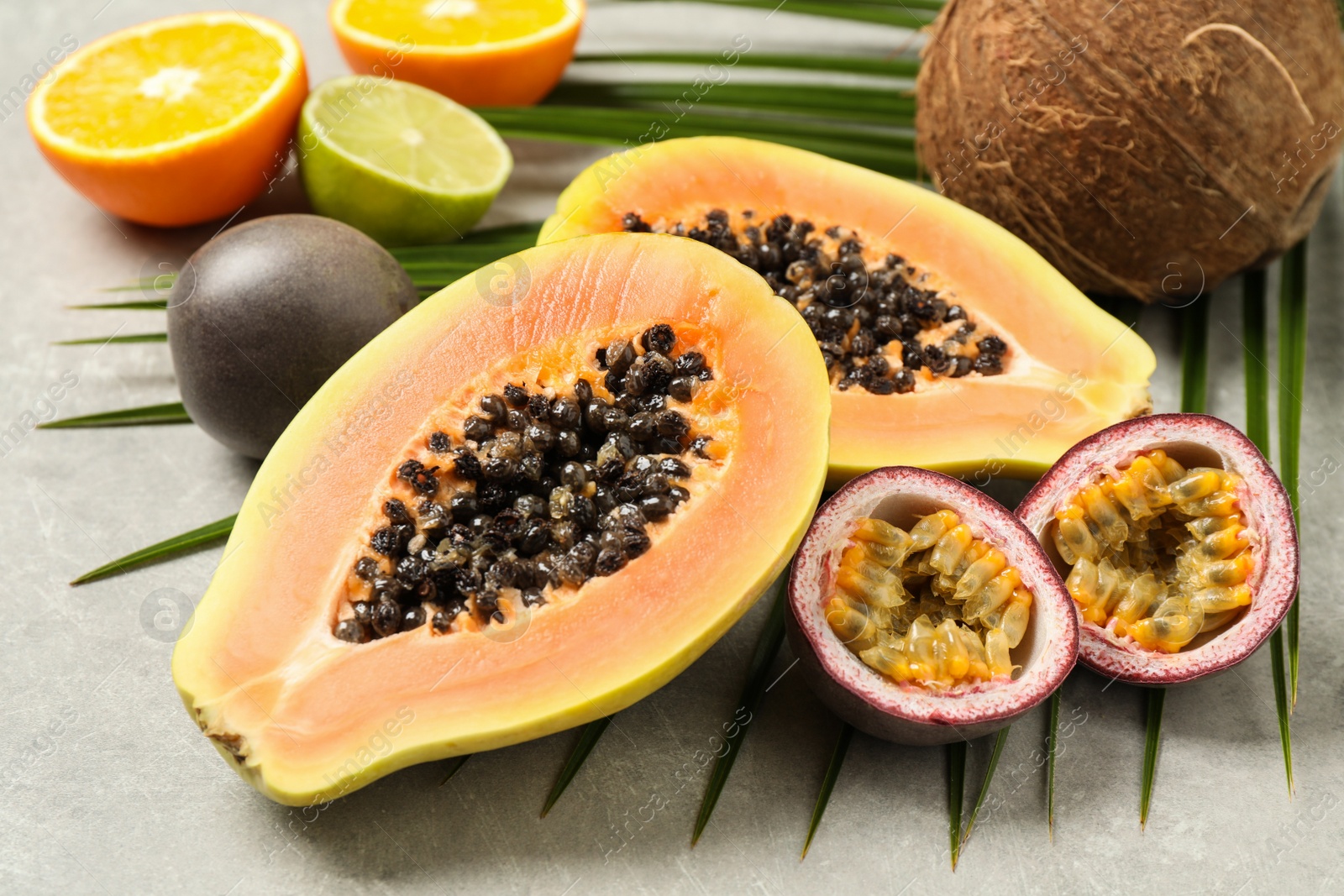 Photo of Fresh ripe papaya and other fruits on light grey table