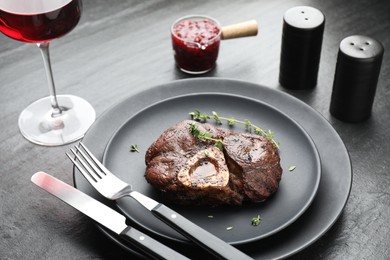 Photo of Tasty grilled beef meat served on black table