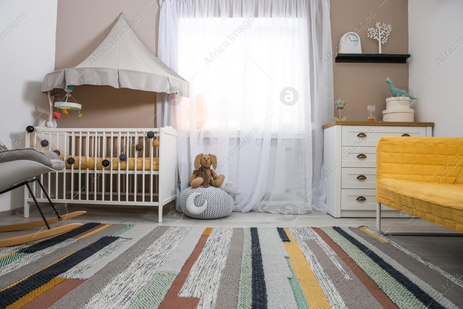 Photo of Cozy baby room interior with crib and rocking chair