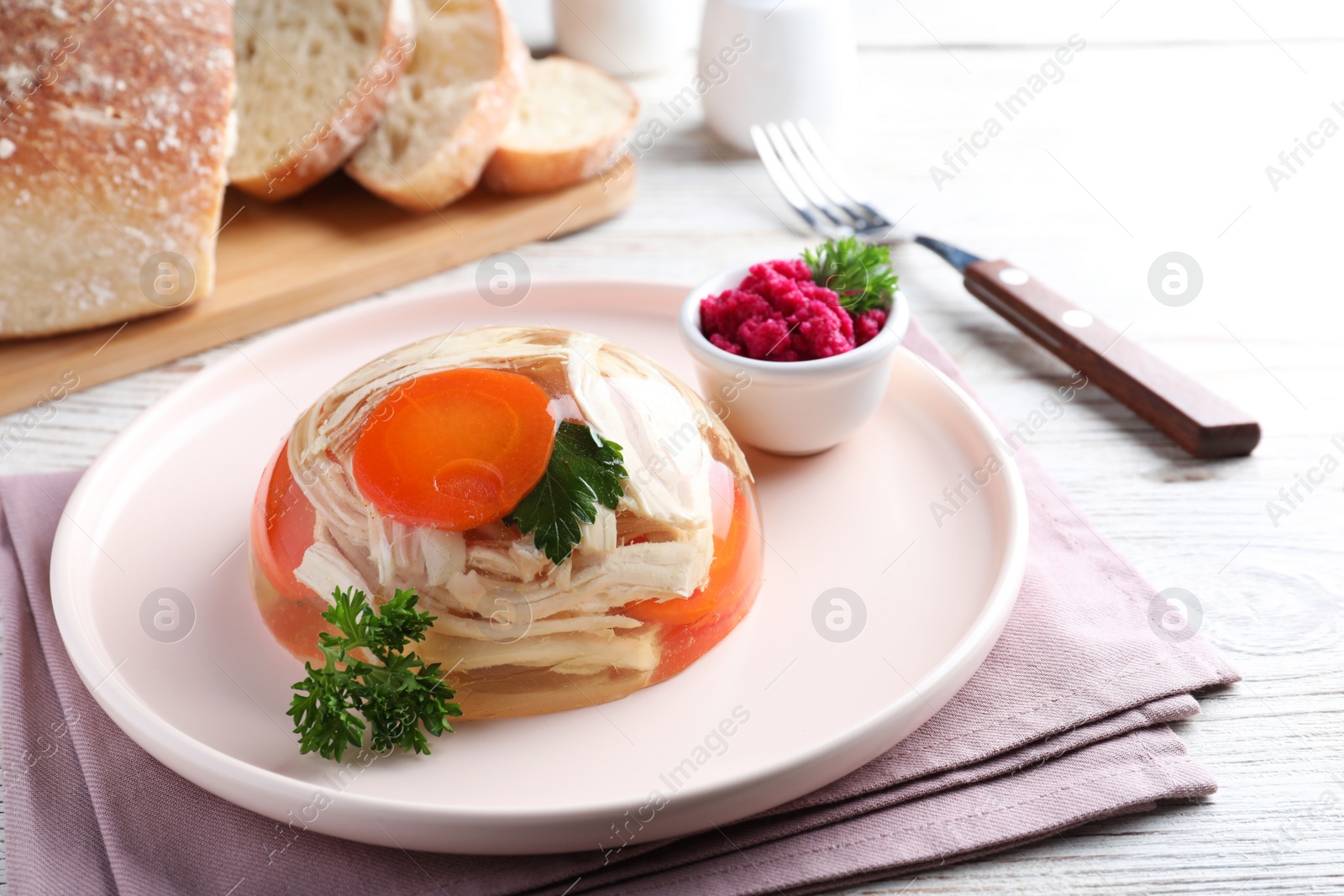 Photo of Delicious chicken aspic served on white wooden table