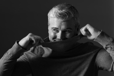 Photo of Portrait of handsome man on dark background. Black and white effect